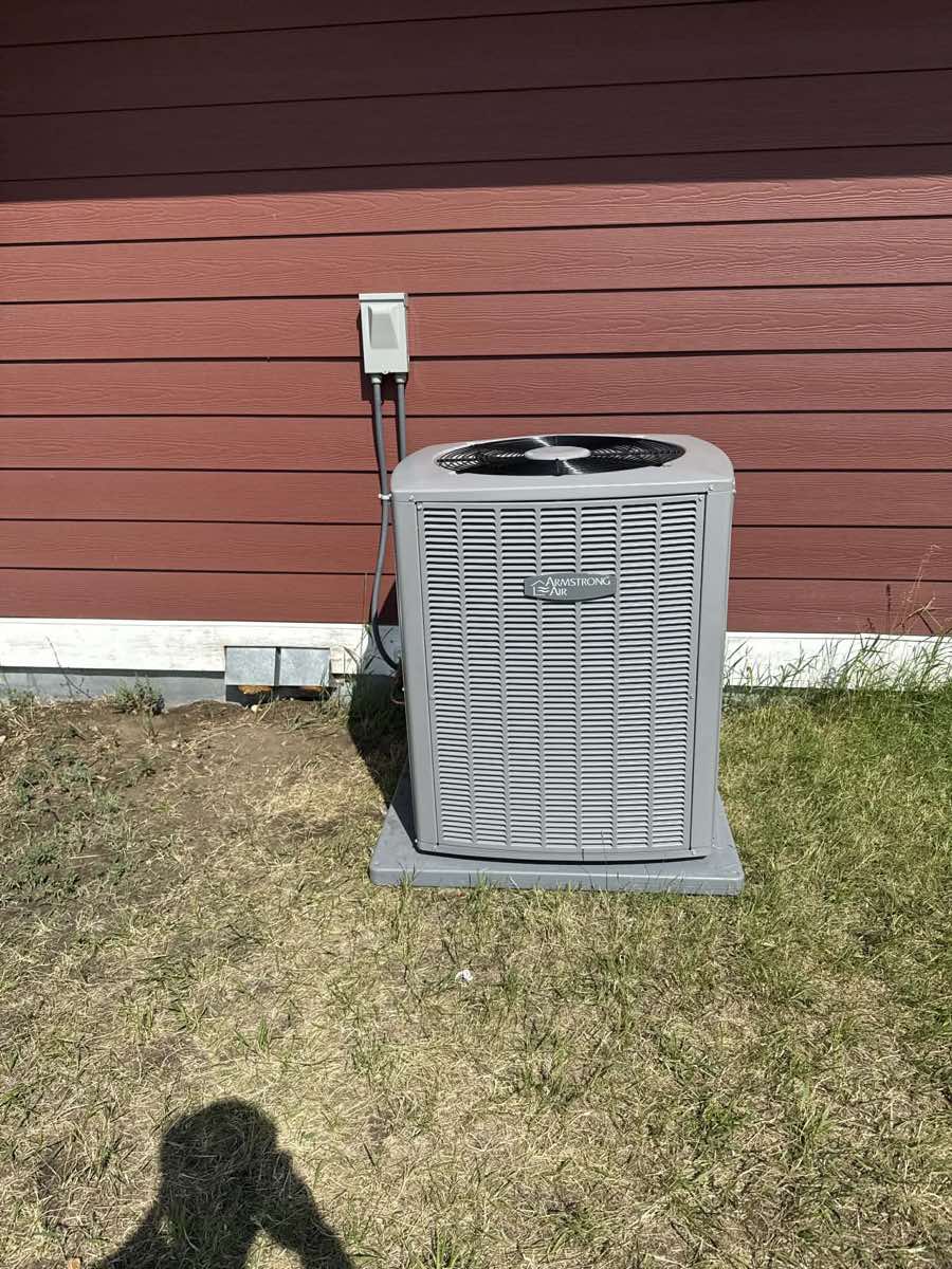 Armstrong Air central air conditioning condenser unit installed outside a Calgary residence