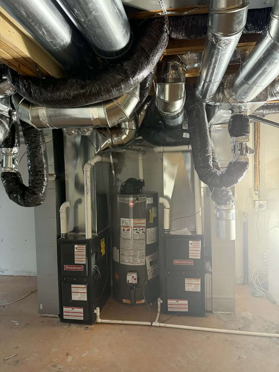 Dual Goodman furnaces with water heater and extensive ductwork in a Calgary basement